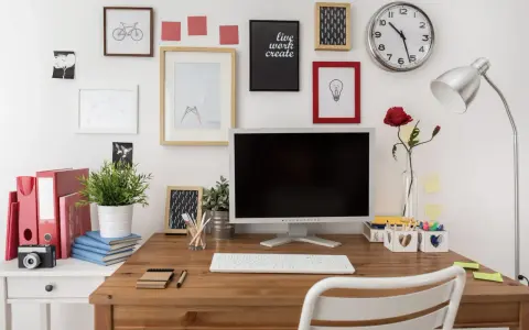 Bureau organisé pour une **optimisation** du travail : écran, clavier, plante verte, et décorations murales inspirantes.