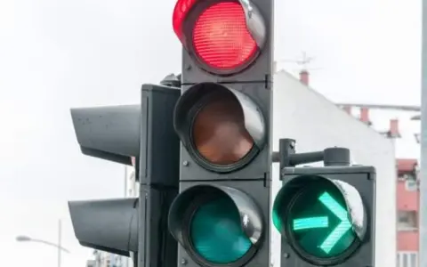 Ampel mit Pfeil nach rechts und ohne. Rot leuchtet, Grün mit Pfeil zeigt Richtung an.