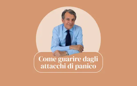 Uomo sorridente in camicia blu, con la scritta "Come guarire dagli attacchi di panico".