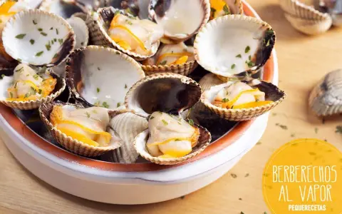 Deliciosos berberechos al vapor, recién cocidos y espolvoreados con perejil fresco. Un bocado del mar.