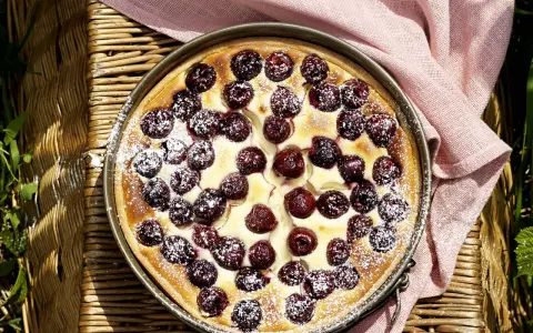 Ein köstlicher Kirschkuchen, bestäubt mit Puderzucker. Perfekt für sommerliche sauerkirschen rezepte.