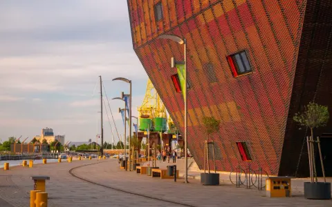 Nowoczesna architektura i portowe klimaty – to właśnie co można zwiedzić w Szczecinie. Widok na nabrzeże z charakterystycznym budynkiem.
