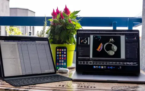 iPad Pro mit Tastatur, iPhone, AirPods und MacBook Pro mit Kopfhörern und Schlüsseln.