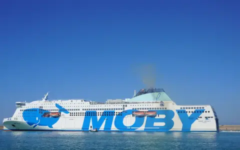 Ogromny prom Moby Legacy z wielorybem na burcie, gotowy do rejsu na Sardynię.