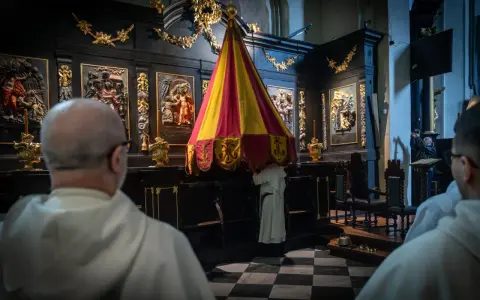 Uroczystość sede vacante w kościele. Mnisi w białych szatach przygotowują baldachim.