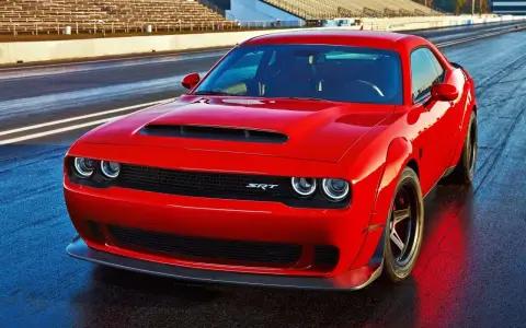 Czerwony Dodge Challenger Demon na torze wyścigowym, gotowy do startu.