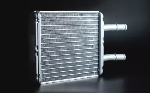 A new heater core, essential for a heater core replacement, sits ready for installation. Its fins are clean and ready to warm your car.
