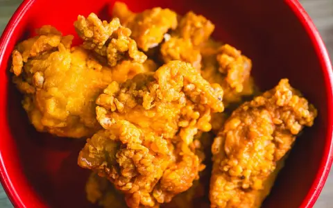 Chrupiący kurczak karaage w czerwonej misce. Idealna przekąska na imprezę.