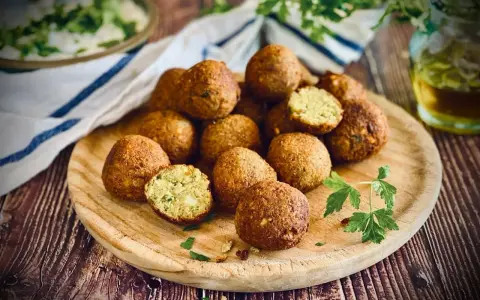 Frisch zubereitete Falafel auf einem Holzbrett, perfekt zum falafel selber machen. Ein Genuss für jeden Liebhaber der orientalischen Küche.