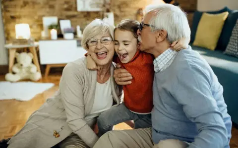 Nonna e nonno abbracciano felici la nipote. Un momento di gioia che sottolinea il diritto dei nonni a vedere i nipoti, un legame prezioso.