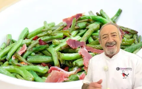 Chef sonriente presenta plato de judías verdes con jamón, ideal para tus recetas.