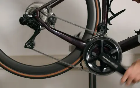 Nahaufnahme einer Fahrradkurbel und des Schaltwerks, während jemand die Kurbel dreht, um die di2 einzustellen.