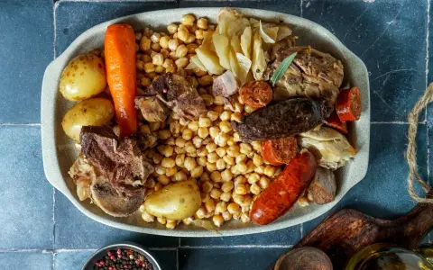Un plato generoso para comer cocido en pueblos de Madrid: garbanzos, patatas, zanahoria, carnes y embutidos.