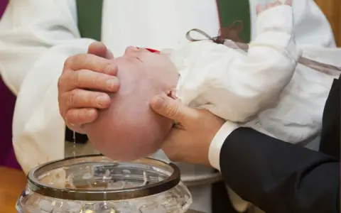 A baby is baptized, a sacred ritual symbolizing new beginnings, as described in the Bible.
