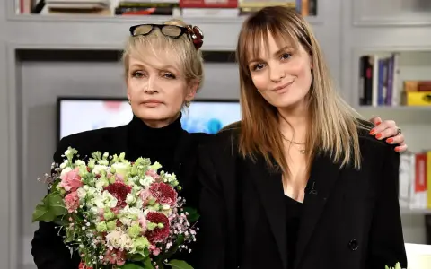 Joanna Biedrzyńska z córką, obie ubrane na czarno, z bukietem kwiatów.