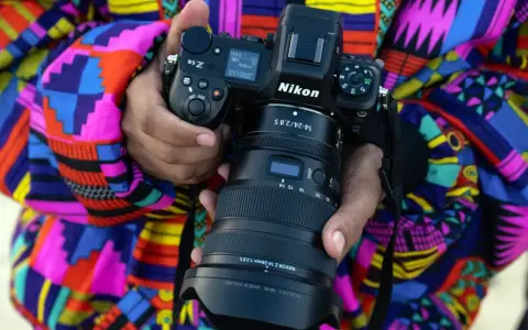 Osoba trzyma aparat Nikon Z6 z obiektywem NIKKOR Z 14-24mm f/2.8 S. Wśród wielu marek aparatów fotograficznych, Nikon wyróżnia się jakością.