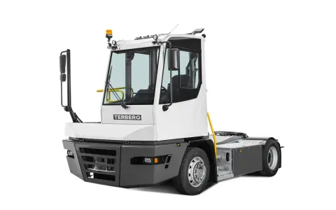 Biały ciągnik terminalowy Terberg z żółtymi elementami i dużymi lusterkami, gotowy do pracy w porcie.