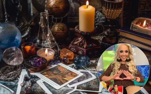 Mesa esotérica con cartas, cristales y velas. Una mujer sonríe haciendo un gesto con las manos, quizás buscando cómo atraer el amor.