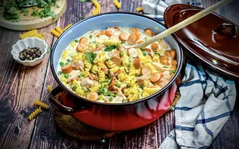 Herzhafte Nudelpfanne mit Würstchen, Erbsen und Hähnchen – ein Gericht, das perfekt für "das perfekte Dinner Rezepte" ist.