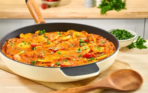 Herzhaftes rezept hackfleisch kartoffeln in einer Pfanne, garniert mit Petersilie und Kirschtomaten.