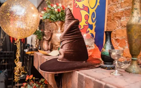 Czapka Mówiąca, złoty balon i bukiet róż tworzą magiczną atmosferę na weselu w stylu Harry'ego Pottera.