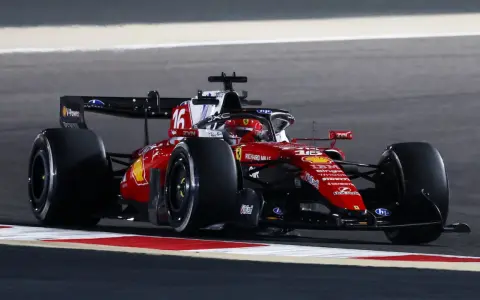 Coche de Ferrari número 16 en plena acción en el GP Bahrein, con el piloto concentrado en la pista nocturna.