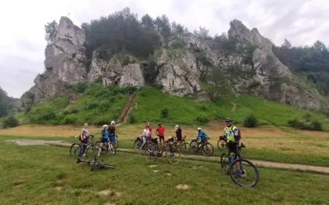 Grupa rowerzystów na tle skalnych ostańców. Jura Krakowsko-Częstochowska rowerem to wspaniała przygoda.