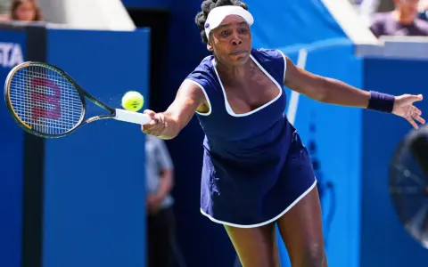Venus Williams golpea la pelota en un partido, demostrando su destreza en los Grand Slams.
