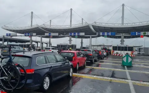 Korki samochodów przed terminalem. Kolejka do odprawy, w tle widać konstrukcje terminalu. Sprawdzanie eurotunel cena.
