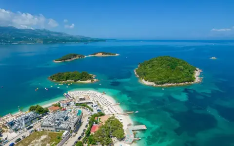 Widok na wyspy w Ksamilu, skąd widać prom na Korfu. Turkusowa woda, plaże i zielone wysepki.