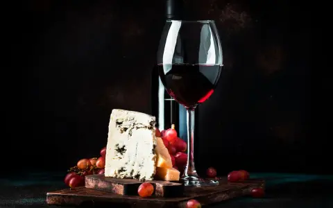 Ein Glas Rotwein, Käse und Trauben. Was ist Portwein? Ein süßer, aufgespriteter Wein, der oft zu Käse serviert wird.
