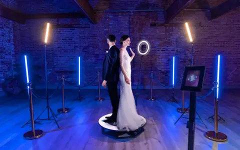 Para młoda na obrotowej platformie fotobudki 360°. Zastanawiasz się, ile kosztuje fotobudka na wesele? To świetna atrakcja!