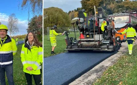 Två personer i varselkläder står framför en asfaltsläggare som lägger nytt asfalt.