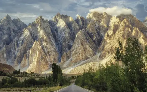 Droga w Karakorum Highway prowadzi przez surowe, skaliste góry oświetlone słońcem.