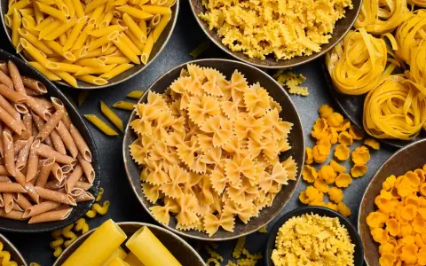 Różne rodzaje makaronu, od penne po farfalle, gotowe do przyrządzenia al dente. Idealne do każdej potrawy.