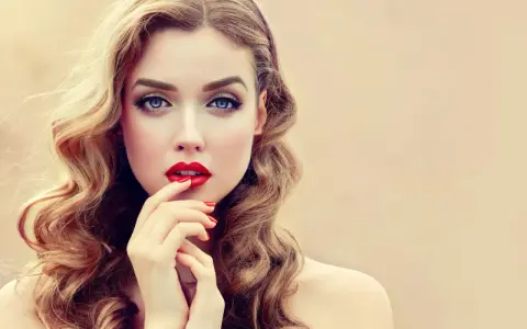 Glamouröse Frau mit voluminösen, welligen Haaren und roten Lippen. So gelingen Hollywood Waves selber machen!