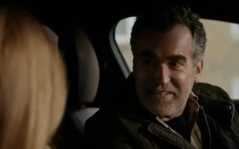 Un uomo sorride in auto, un momento di complicità nella serie turca "La Famiglia".