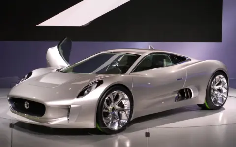 Silberner Jaguar C-X75 mit Flügeltür, der auf einer Messe ausgestellt wird.