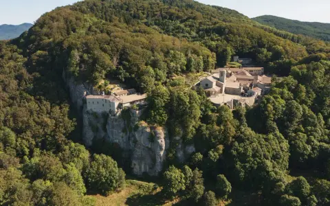 Il Santuario della Verna, incastonato tra i boschi, si erge maestoso su uno sperone roccioso. Un luogo di pace e spiritualità, meta di pellegrinaggi da Rimini e oltre.