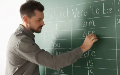 Nauczyciel pisze na tablicy "Subject", "Verb 'to be'". Przygotowanie do egzaminu z certyfikatem C1 angielski.