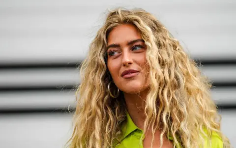 Frau mit voluminösen, blonden Locken, die zeigen, wie man Locken selber machen kann.