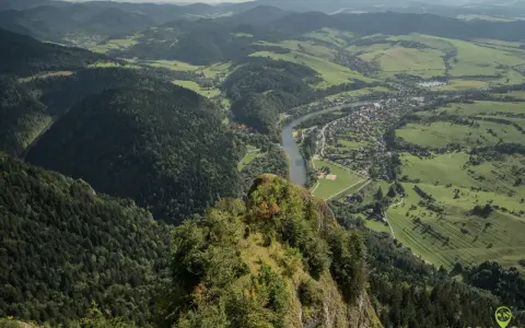 Widok z góry na Trzy Korony. Rzeka Dunajec meandruje przez zieloną dolinę, w której leży malownicza miejscowość.