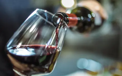 Rotwein fließt ins Glas. Ein Schluck für die Gesundheit und den Genuss.