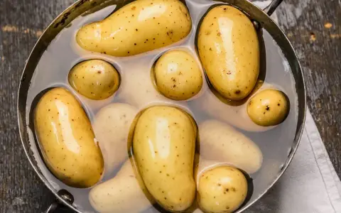 Des pommes de terre nouvelles dans une casserole d'eau, prêtes pour une délicieuse recette de pomme de terre.