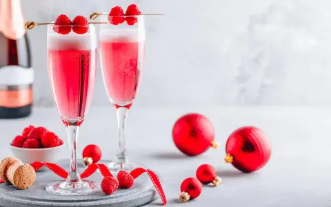 Deux coupes de soupe champenoise framboise pétillante, décorées de fruits rouges frais, prêtes pour les fêtes.