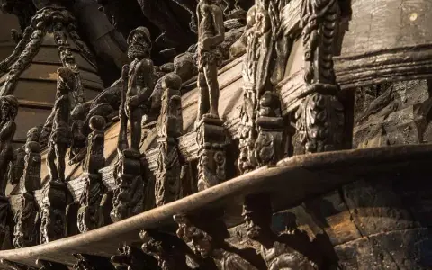 Detaljerade träskulpturer på Vasamuseet visar en rad figurer och ornament.