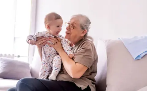 Abuela sonríe a su nieto varón, compartiendo un momento tierno. Ella tiene frases de amor para él.