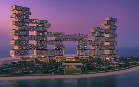 Nowoczesny hotel Atlantis The Royal w Dubaju o architekturze z otworami, o zmierzchu.