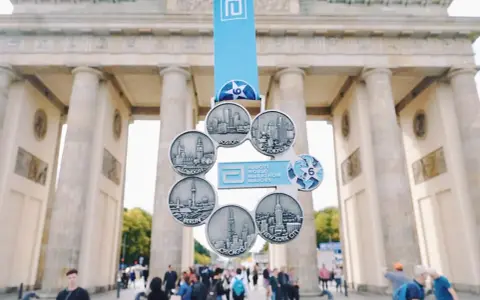 Medal za ukończenie korony maratonów świata z widokiem na Bramę Brandenburską.