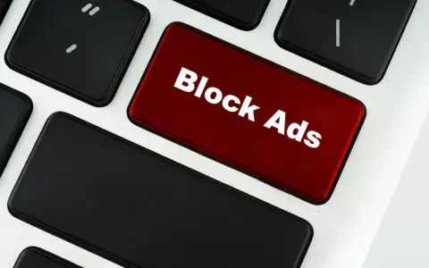 Czerwony klawisz z napisem "Block Ads" symbolizuje, co to jest adblock – narzędzie blokujące reklamy.